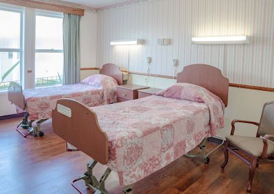 A semi-private room at the Woodland Nursing and Rehab facility showing bright open windows