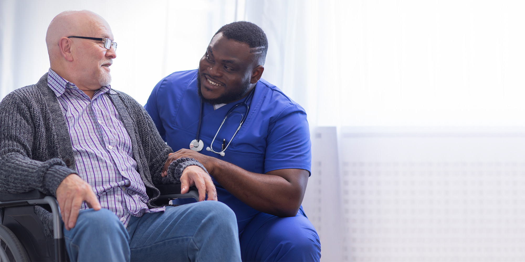 Rehab therapist with a resident in a wheelchair in the rehab gym