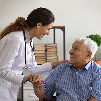 Doctor smiling and placing her hand on a patient's shoulder